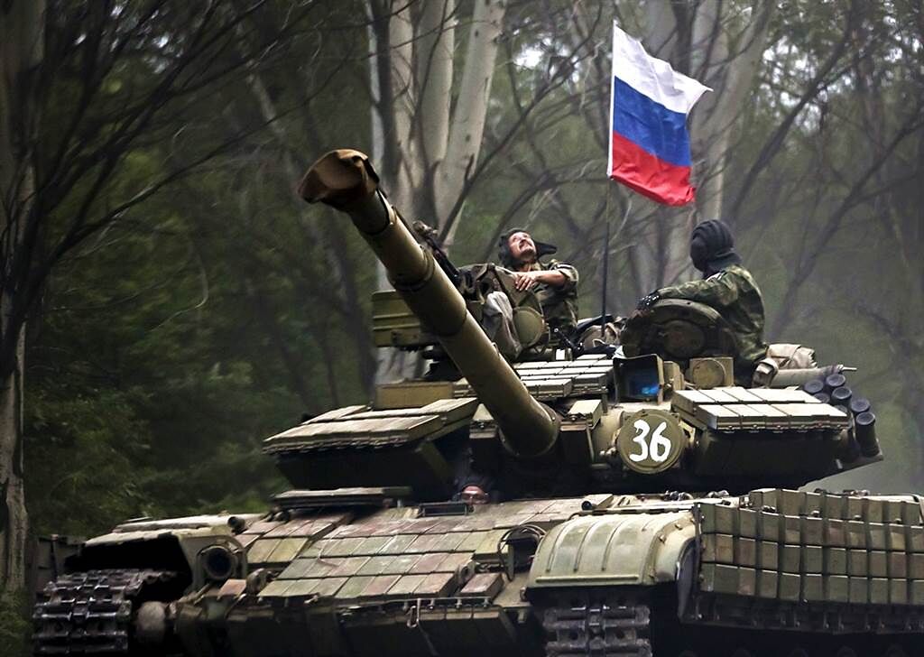 俄羅斯總統普丁（Vladimir Putin）宣布承認烏克蘭東部2個分離主義共和國為獨立實體，並且分別和2國簽署條約，外媒指這代表俄羅斯取得在這2個區域建立軍事基地的權利。圖為2015年一名親俄份子在頓內茨克升起俄羅斯國旗的畫面。（資料照／美聯社）