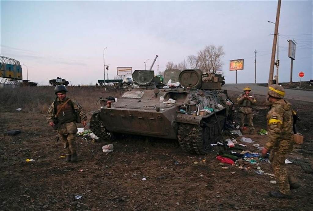 烏克蘭士兵檢查遭擊毀的甲車。(圖/路透社)