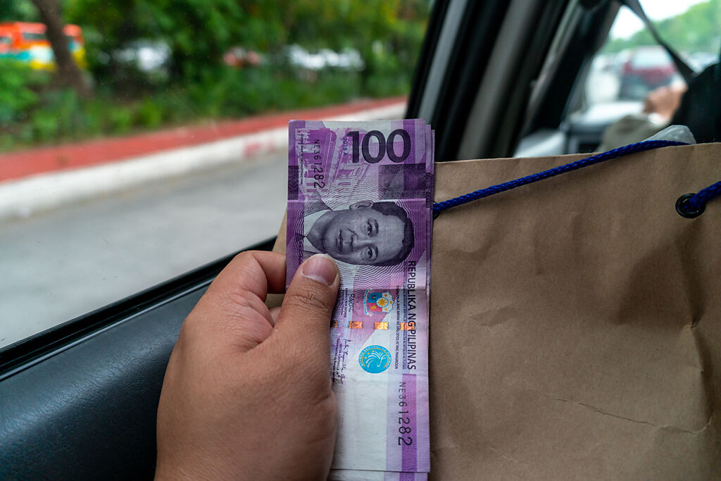 菲律賓窮學生打電話向媽媽訴苦，全身只剩下100披索（約新台幣54元），一名陌生女子聽到後，偷偷遞上紙條和金錢解圍。（示意圖／達志影像）
