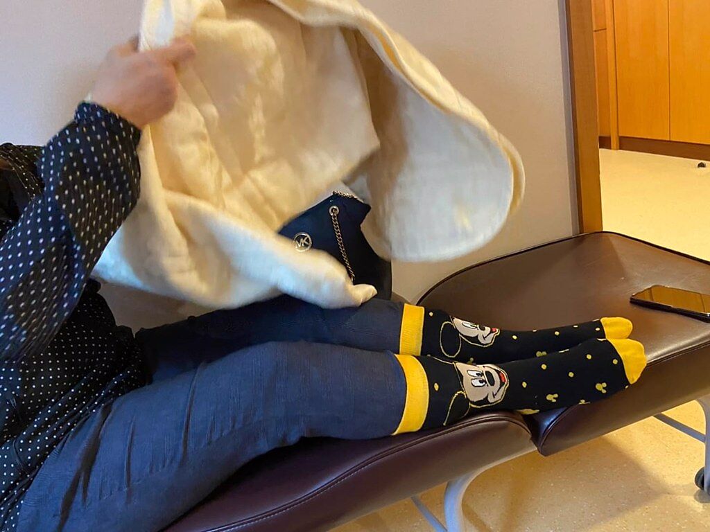 1名女網友日前到醫院陪伴親友，但因為認為醫院冷氣太冷，於是帶了條「亮黃色」棉被裹住全身睡覺，照片曝光她笑說「好像帶錯被子，看起來好嚇人」。（翻攝自臉書「爆怨公社」）