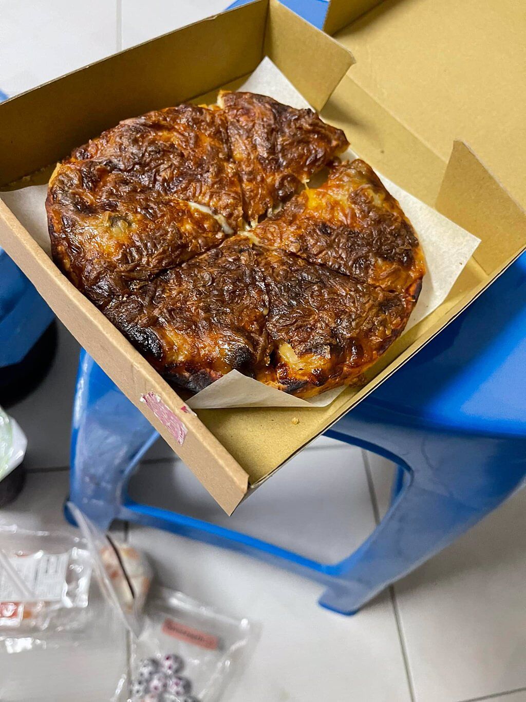 名網友用外送點了個人獨享的披薩，但送來時卻驚見整片披薩幾乎全烤焦，上頭佈滿深咖啡色，讓他痛批「這三X」。（翻攝自臉書「外送員的奇聞怪事」）