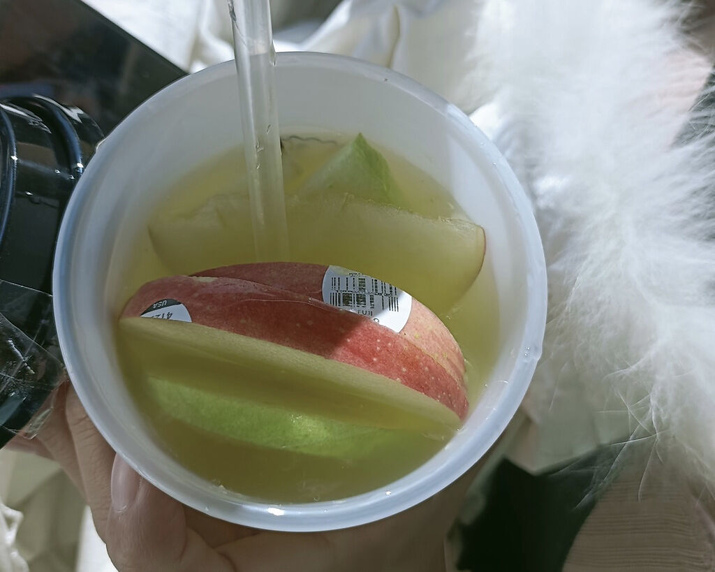 一對夫妻買杯水果茶消暑，意外發現杯中的切片蘋果上竟還黏著標籤。（圖／翻攝自臉書社團爆廢公社）