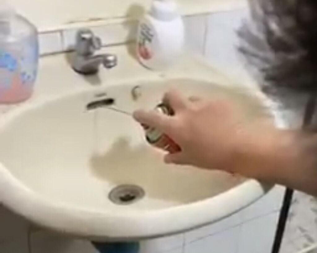 一名男網友往洗手台溢流孔噴灑殺蟲劑，下秒畫面讓網友直呼噁心。（圖／翻攝自臉書社團爆廢公社二館）