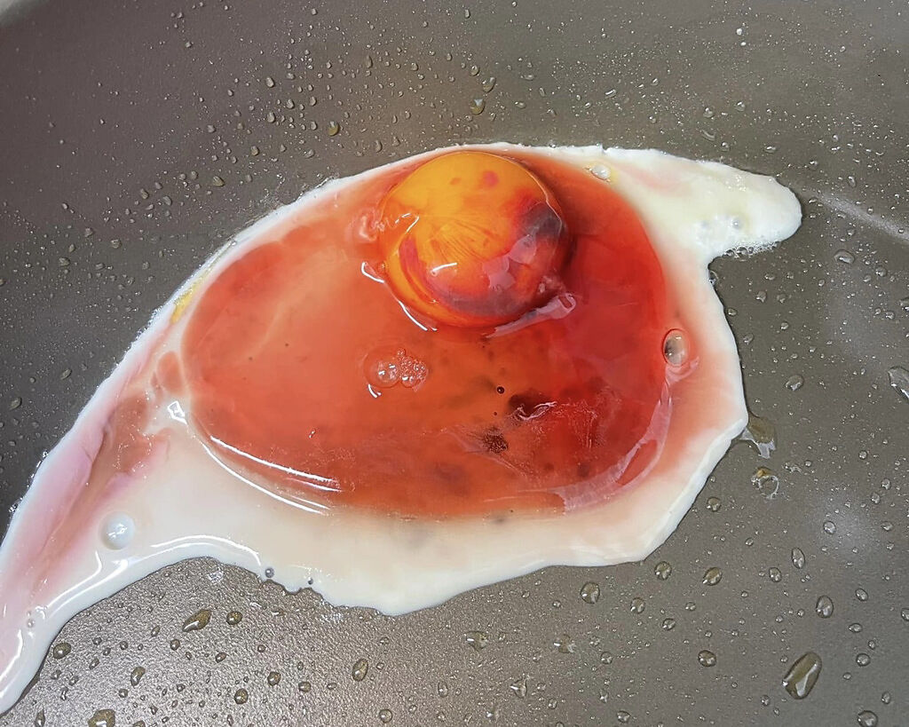 一名男網友今天早上煎荷包蛋時發現，雞蛋的蛋白竟呈現血紅色。（圖／翻攝自臉書社團爆怨公社）