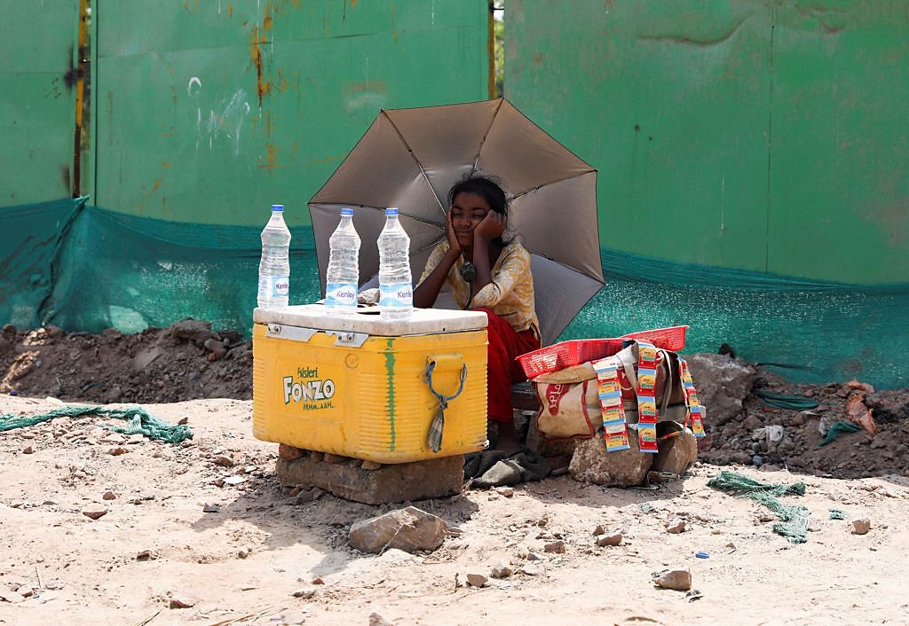 一個女孩大熱天在路邊賣水（圖／路透）