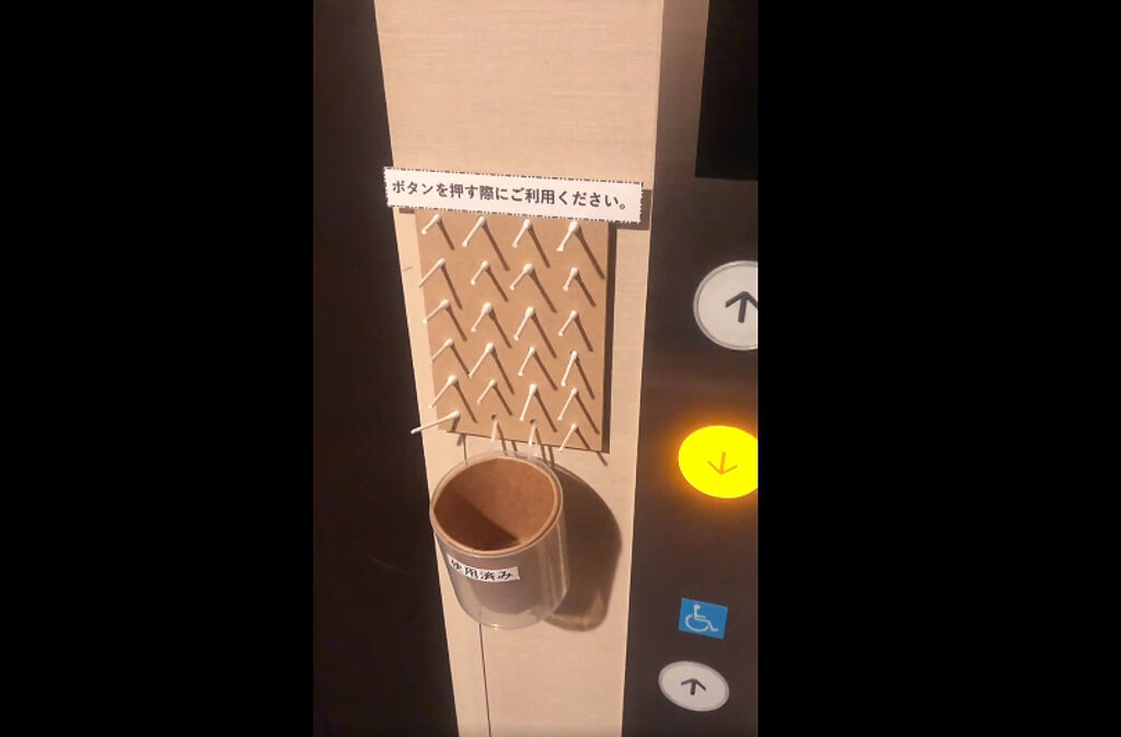 日本人在電梯按鈕旁插了整面的棉花棒。(圖/截自小林賢伍臉書)