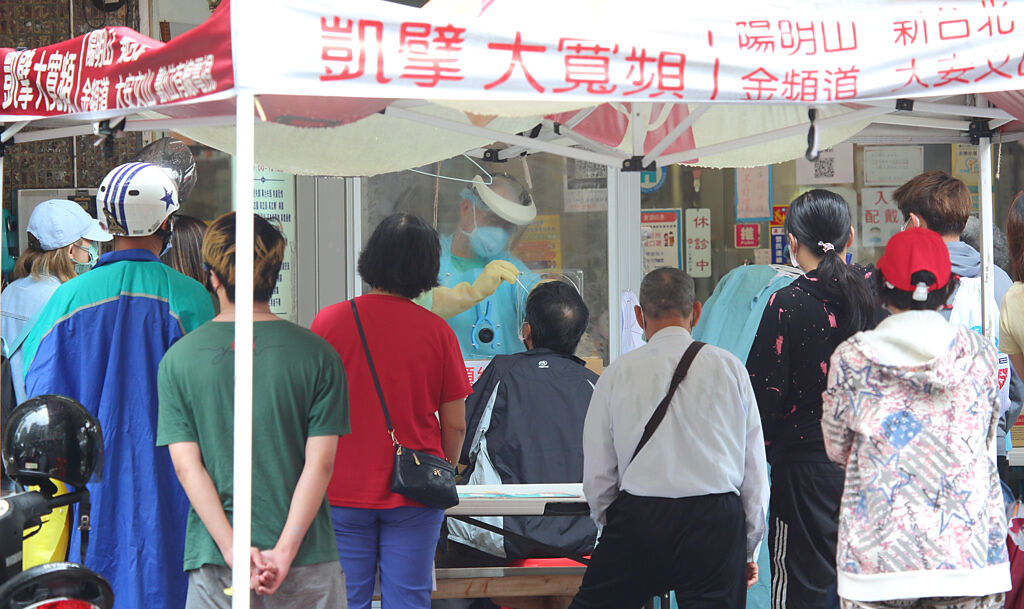 台北市一家診所提供PCR篩檢服務，預約民眾在診所門口擠成一團。（張鎧乙攝）