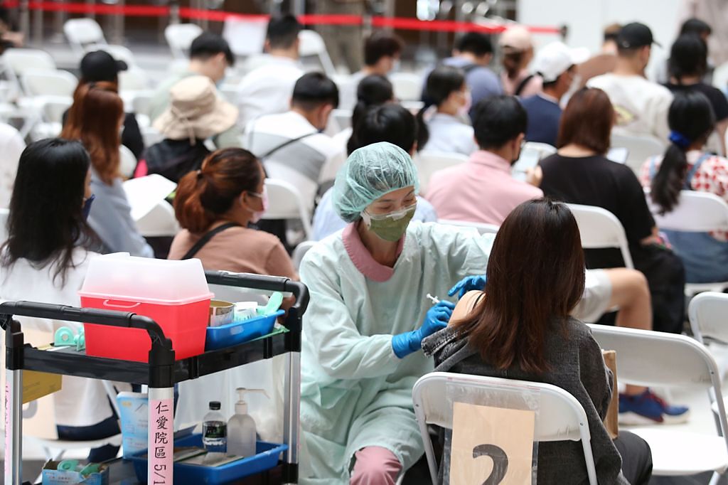 4月起國內疫情再度升溫，不少民眾到台北車站注射站等待施打疫苗。（王英豪攝）