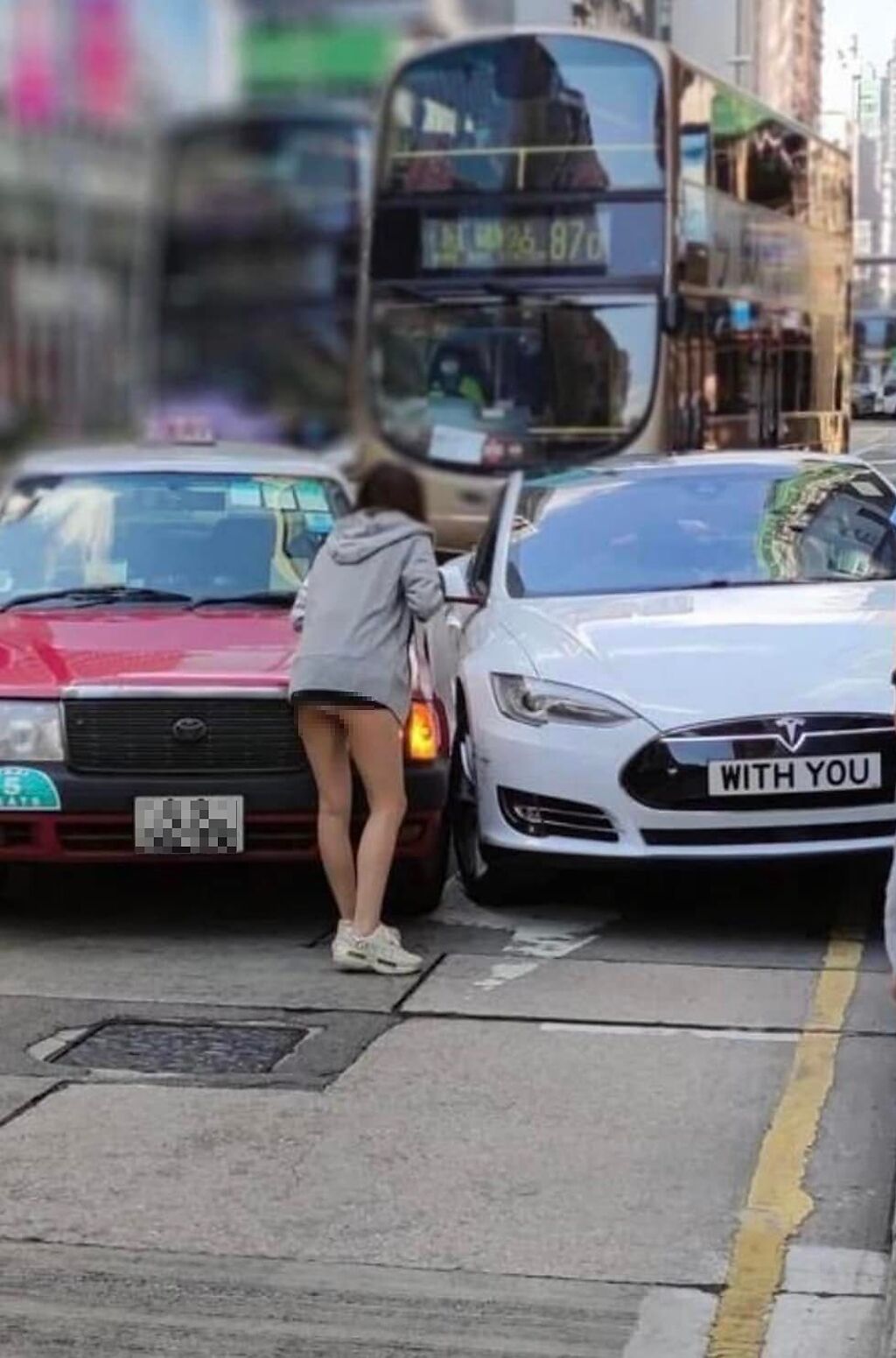 男子分享疑似是香港車禍的照片，照片中的Tesla車牌與穿短裙的正妹都成為網友討論焦點。（翻攝自臉書爆廢公社）