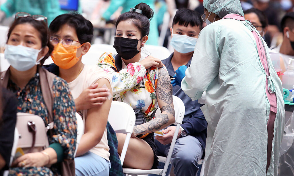 疫情升溫之際，不少民眾到台北火車站接種站施打疫苗，以降低染疫後轉中、重症的風險。非新聞當事人。（范揚光攝）
