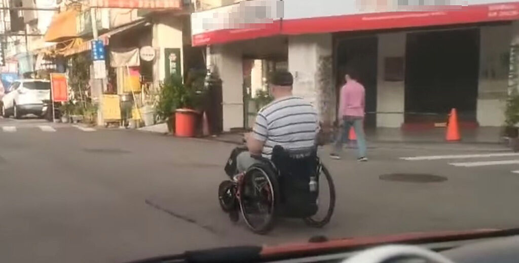 輪椅阿北大搖大擺地行駛在馬路中。（圖／翻攝自爆廢公社2館）