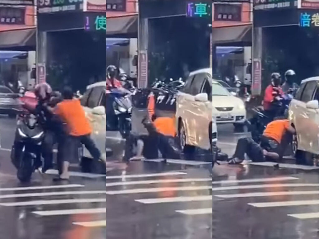 外送員與1名駕駛當街扭打，男駕駛將外送員壓制在地扭打，過程中疑似揮拳方向失誤，竟將手臂伸進轎車的後輪裡卡住。（翻攝照片）