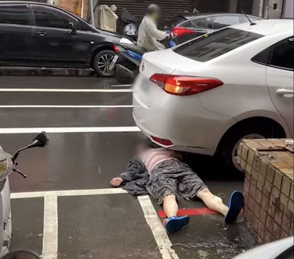 基隆市一名婦女疑似欲假車禍詐財，突然躺在轎車的車下。（翻攝自記者爆料網）