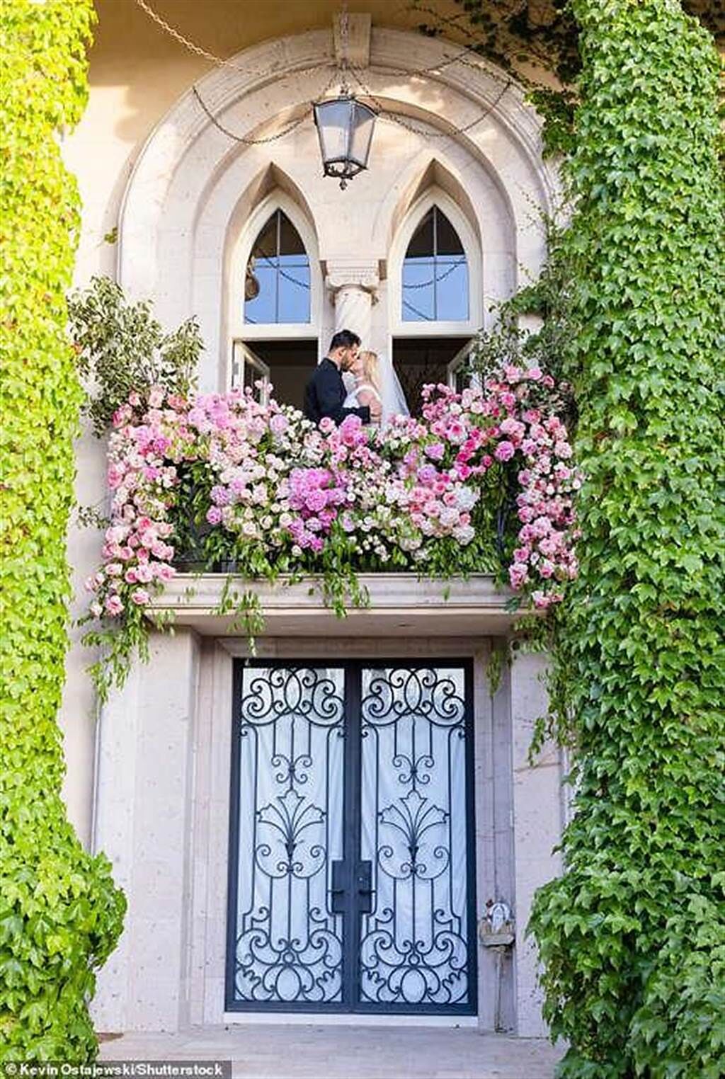布蘭妮和老公在佈滿玫瑰花的窗台親吻，宛如童話。（翻攝Britneyspears IG）