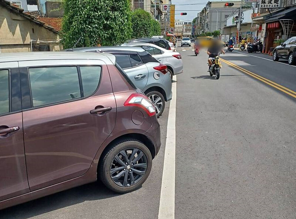 彰化市進德路上有多輛轎車以斜插式停放在路邊，遭到警方開罰。（翻攝自臉書社團《彰化人大小事》）