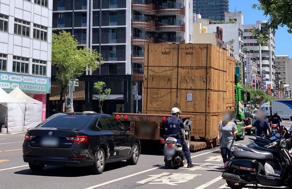 高雄街頭出現神秘的巨形木箱，身旁還有警察及憲警護送，讓路過民眾都非常驚奇。(圖/翻攝自臉書「爆廢公社」)