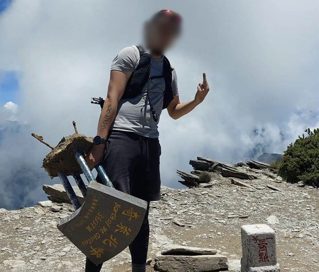 張姓男子2年前曾在奇萊北峰遛鳥拍照，被移送法辦，如今又拿著斷掉的奇萊北峰三角點標示牌拍照，引起爭議。（翻攝照片）