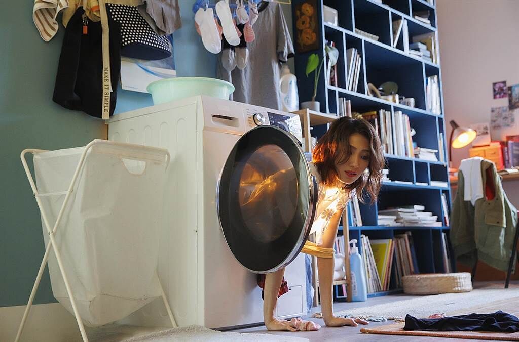 ↑戴佩妮為拍攝新歌MV，鑽進洗衣機。（妮樂佛x仁仁娛樂提供）