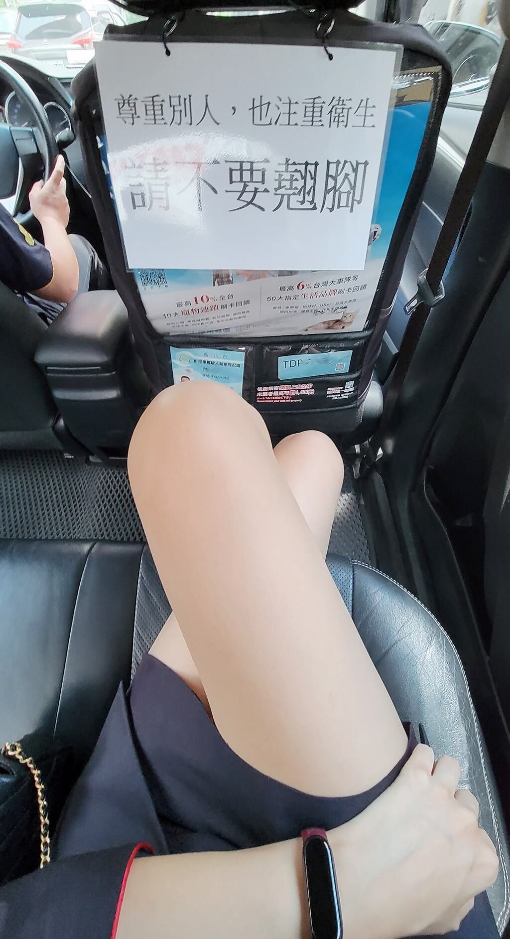 OL在計程車內看見「請不要翹腳」公告，並且拍下PO網，竟遭網友歪樓「這雙腿很可以」。（翻攝自臉書爆廢公社公開版）