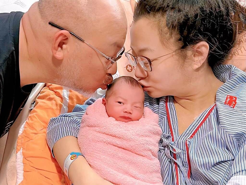 劉亮佐、趙小僑親吻剛出生的女兒。（經紀人林修毅提供）