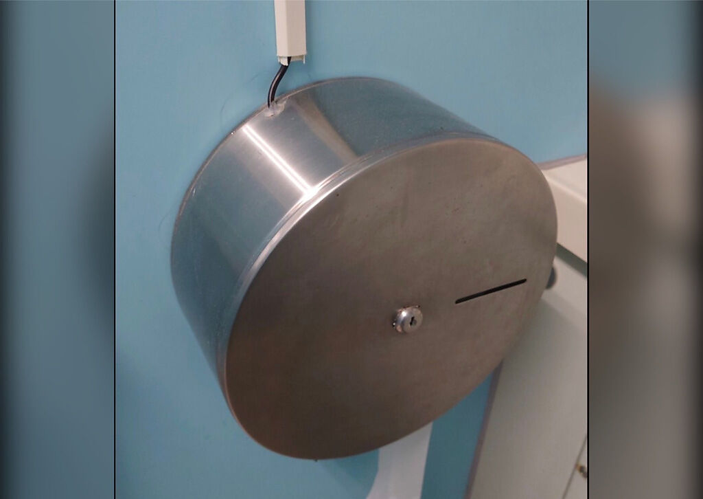 一名男網友發現公廁的衛生紙架上連接著一條黑色電線，好奇用途為何。（圖／翻攝自臉書社團路上觀察學院）