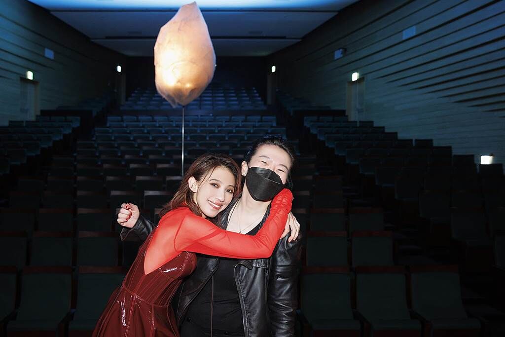 戴佩妮（左）日前拍攝新歌MV，開心導演洪詩婷在懸空的巨繭前留影。（妮樂佛X仁仁娛樂提供）