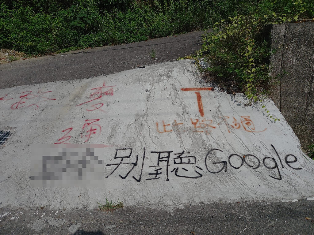 網友在高雄中寮山某路面發現有黑色大字寫「X別聽Google」，還有「此路不通」、「麥通」等字，疑似是駕駛或當地民眾好心幫忙在地上寫字提醒用路人。（翻攝自臉書「爆廢公社」）
