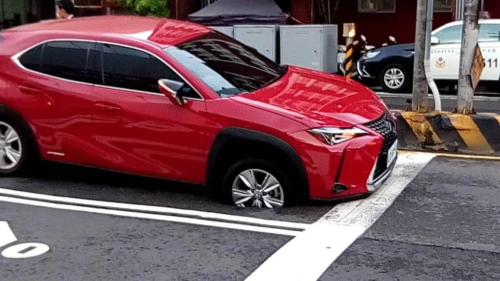 台南市南區健康路與金華路口突然道路塌陷，一輛停等紅燈的凌志汽車右前輪陷入地面。（讀者提供／程炳璋台南傳真）