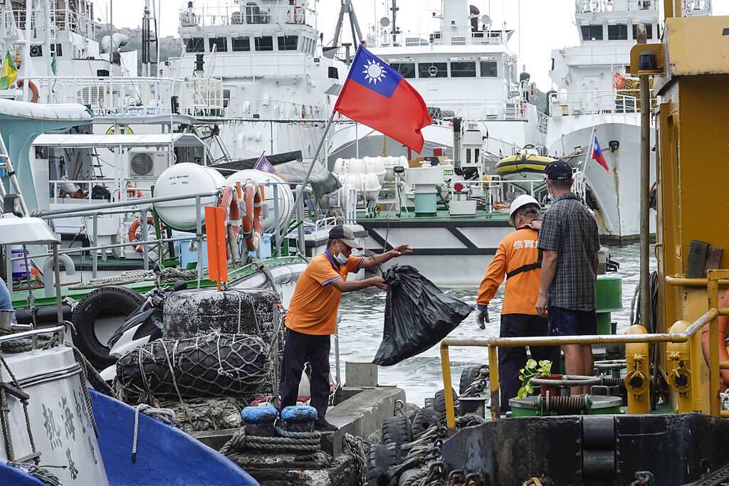 颱風逼近，基隆港區工作人員忙清理垃圾及漂浮物。（黃子明攝）