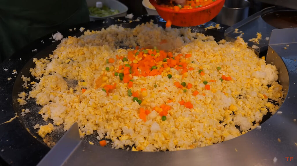 未料老闆炒到一半，在蛋炒飯上加入了三色豆，讓網友瞬間哀號直呼「這不是台灣美食」。(圖／YouTube@Terry Films)