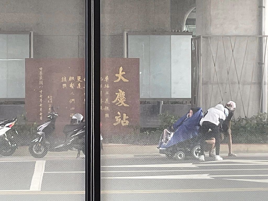 3名年輕人在路邊替輪椅伯穿雨衣。（圖／翻攝自爆料公社）