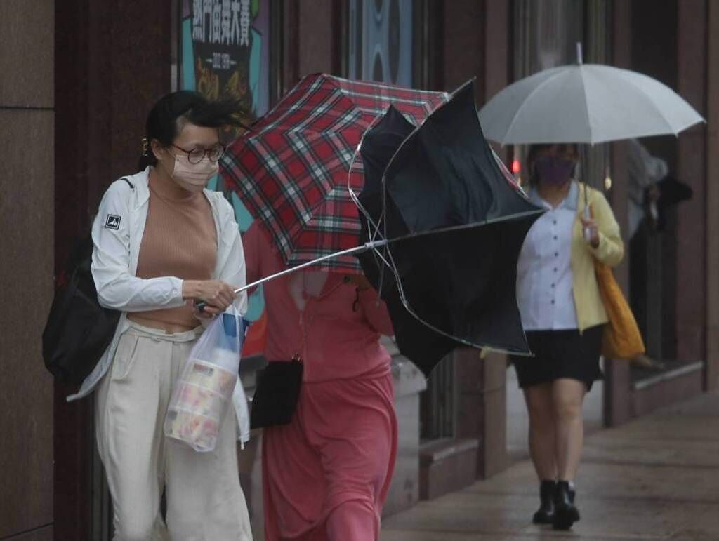 緩步北上的中颱梅花今日繼續發威，民眾攜帶雨具也抵擋不了強勁的陣風。（示意圖，陳君瑋攝）