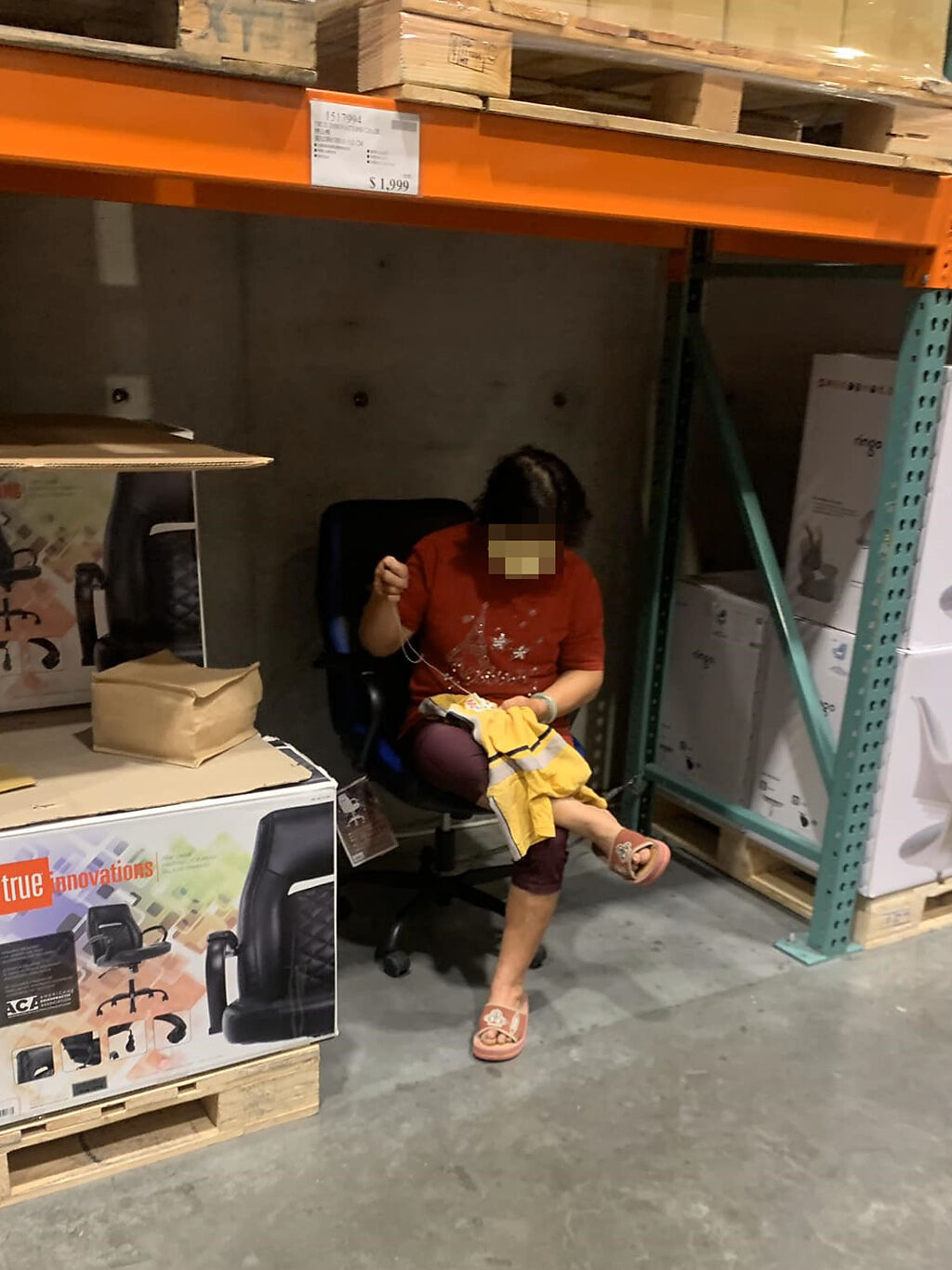 阿嬤「自帶針線」悠然自得地坐在販售商品展示的椅子上縫衣服。(翻攝臉書路上觀察學院)