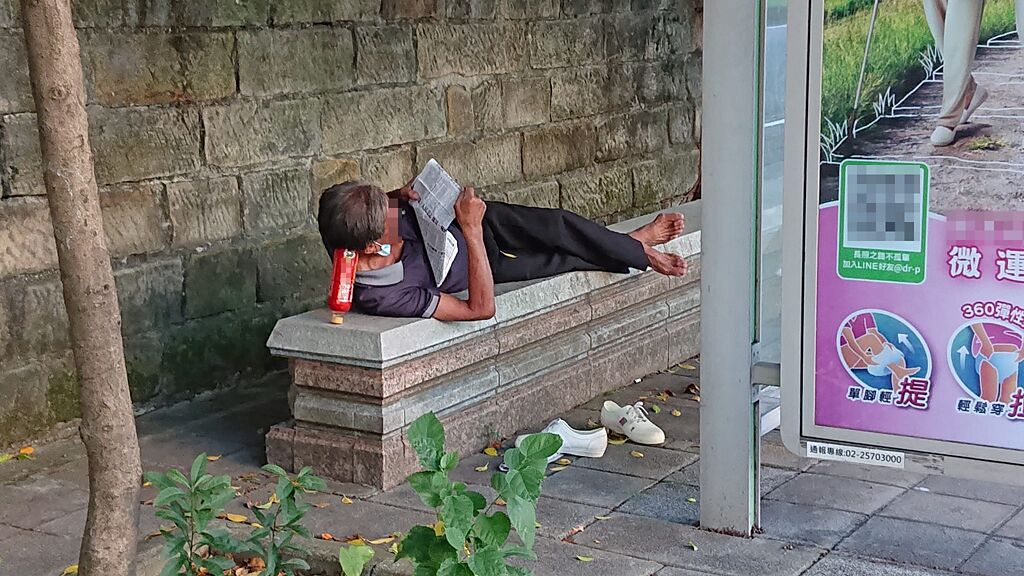 阿伯側躺在石椅上，竟是用保特瓶「蓋子下瓶底上」的方式撐住頭看報。（翻攝自臉書路上觀察學院）