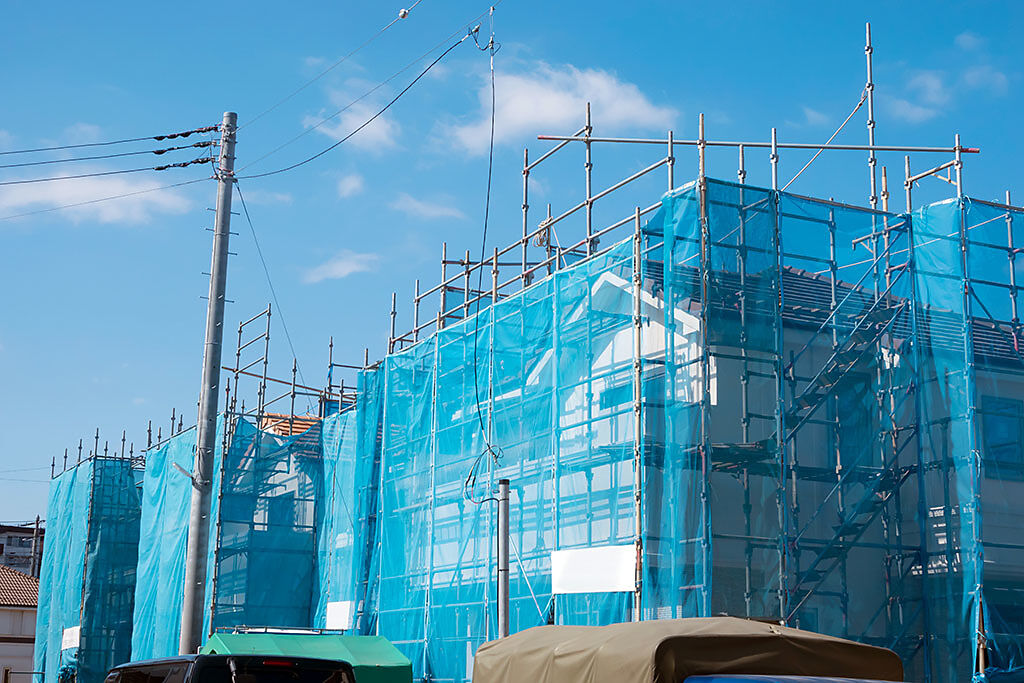施工大樓外圍覆蓋著天藍色的帆布網，宛如形成一層保護色，隱身在天空中。（示意圖／達志影像）