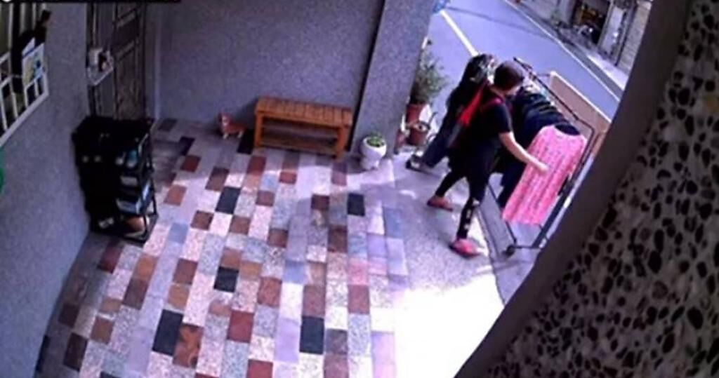 一名網友PO出影片表示，鄰居竟把曬衣架放在他家門口，直接把要曬的衣服掛在上面，還擋住整個大門。（圖／翻攝臉書爆料公社二社）