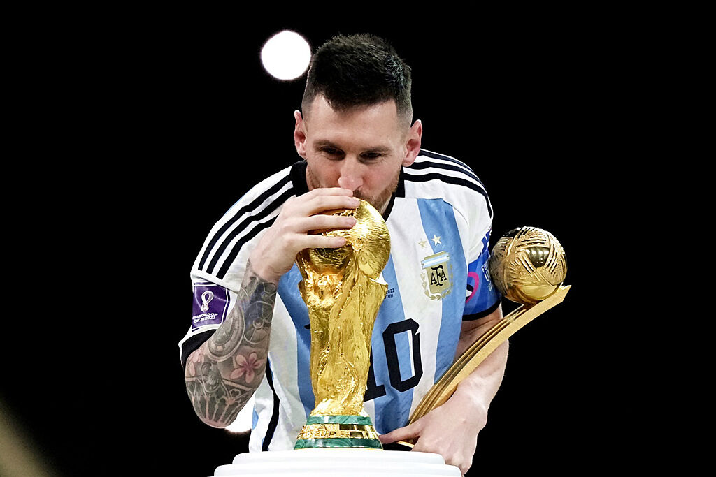 阿根廷18日在卡達世足賽冠軍戰中擊敗法國封王，阿根廷球星梅西親吻大力神盃。（圖／美聯社）