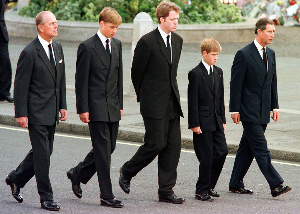 1997年，黛妃葬禮當天，年僅12歲的哈利隨祖父菲利普親王、父親查爾斯、哥哥威廉緊跟靈柩後頭，一身黑色西裝、低著頭，這陰鬱的神情被鏡頭記錄下。 (圖/美聯社)  

