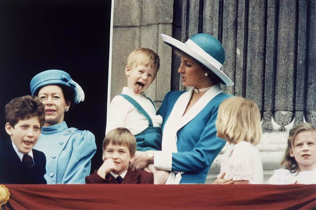 圖為1988年王室成員在白金漢宮陽台亮相的畫面，圖中伸長舌頭、由黛妃抱著的小男孩正是哈利王子，前排托腮男孩為威廉王子。（資料照片／美聯社）