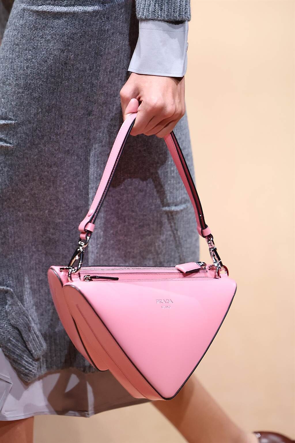 Prada 秀上的粉色三角包，一分為二的設計讓容量更大。(CFP)