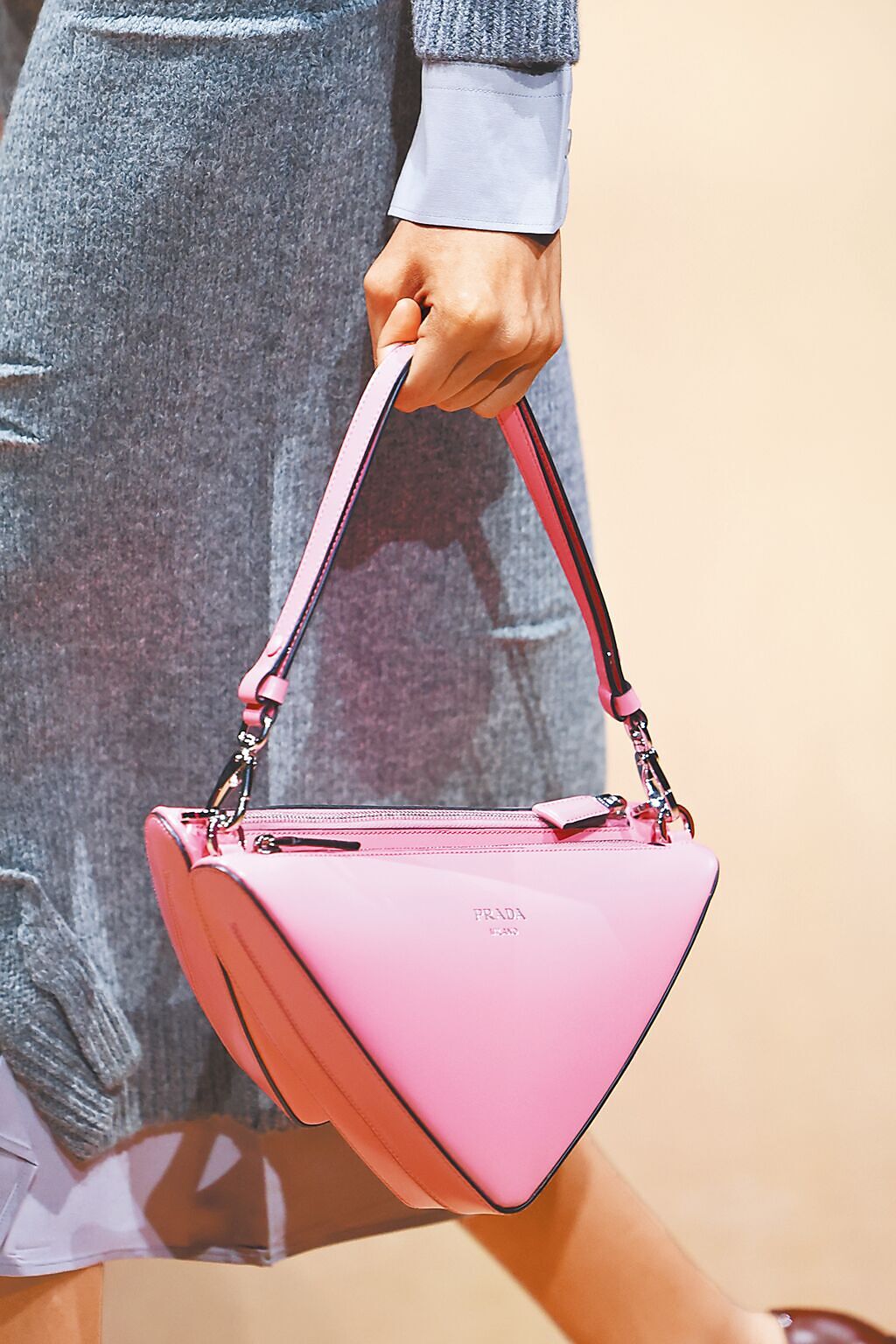 Prada秀上的粉色三角包，一分為二的設計讓容量更大。（CFP）