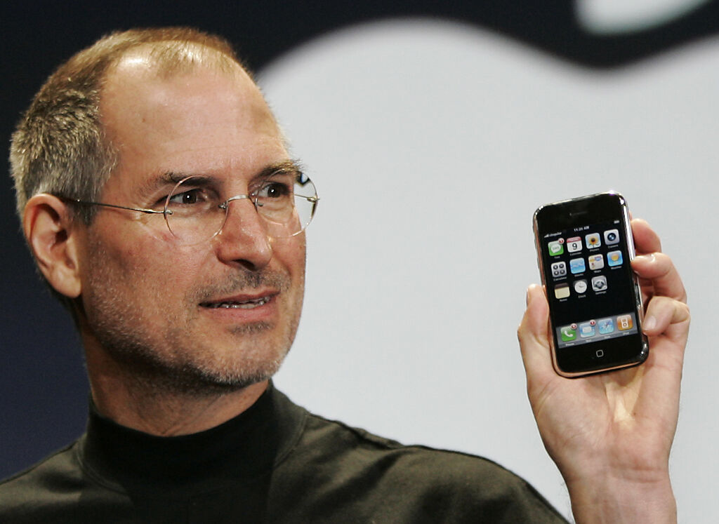 賈伯斯手持第一代iPhone手機亮相。（圖／美聯社）